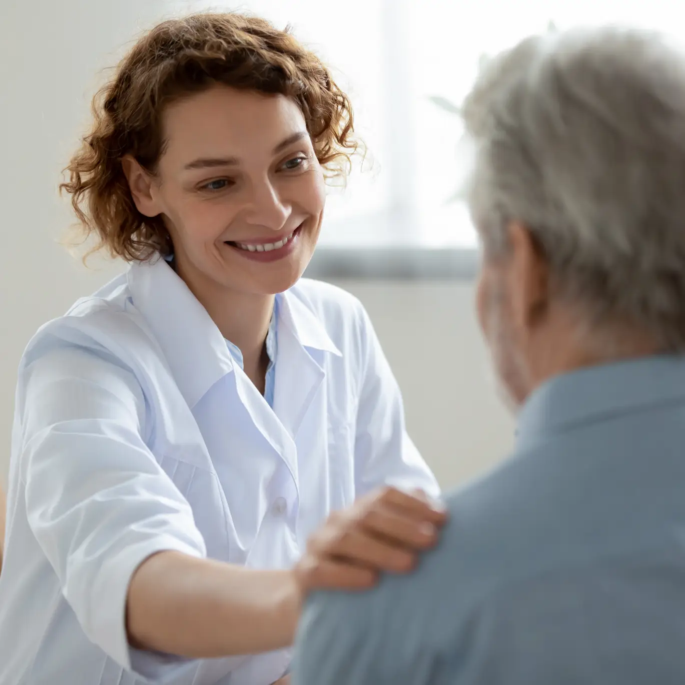 Care professional speaking with an older adult, representing person-centered care coordination and supportive guidance in New York