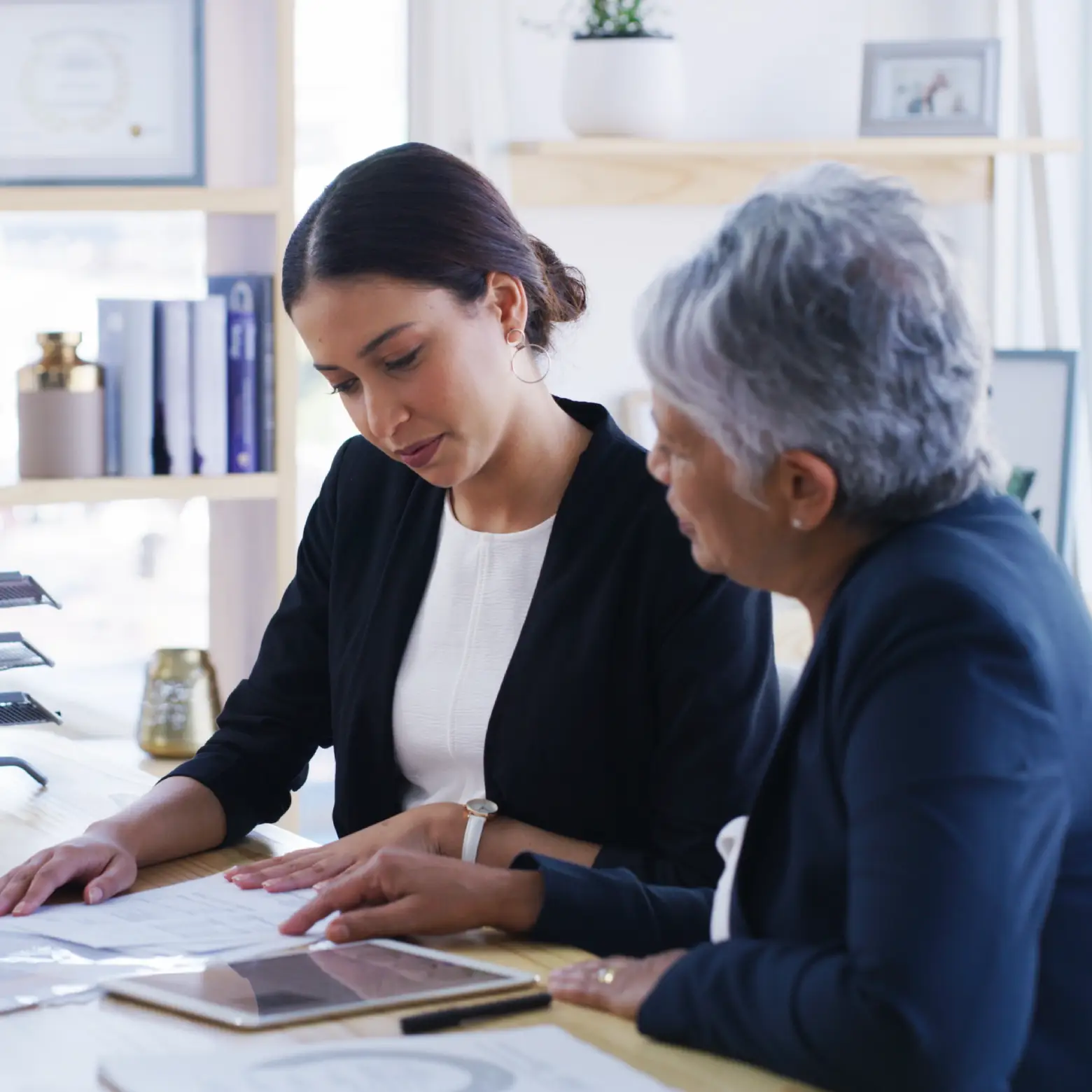 Care professional assisting an older adult with paperwork, representing Step 3 application and documentation for Medicaid Waiver Programs in the Bronx